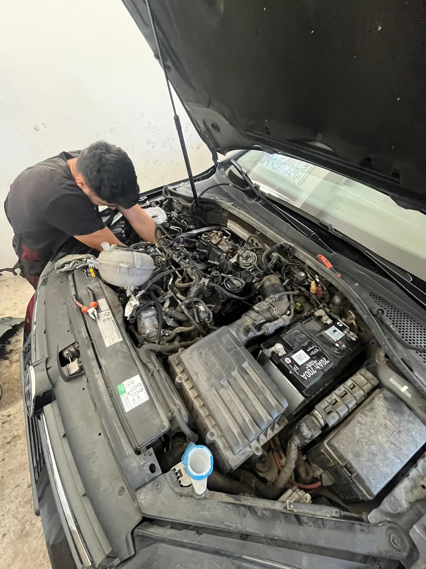 Motorový priestor auta s autobatériou počas servisu v autoservise Ludato Family na Odborárskej, Bratislava Nové Mesto