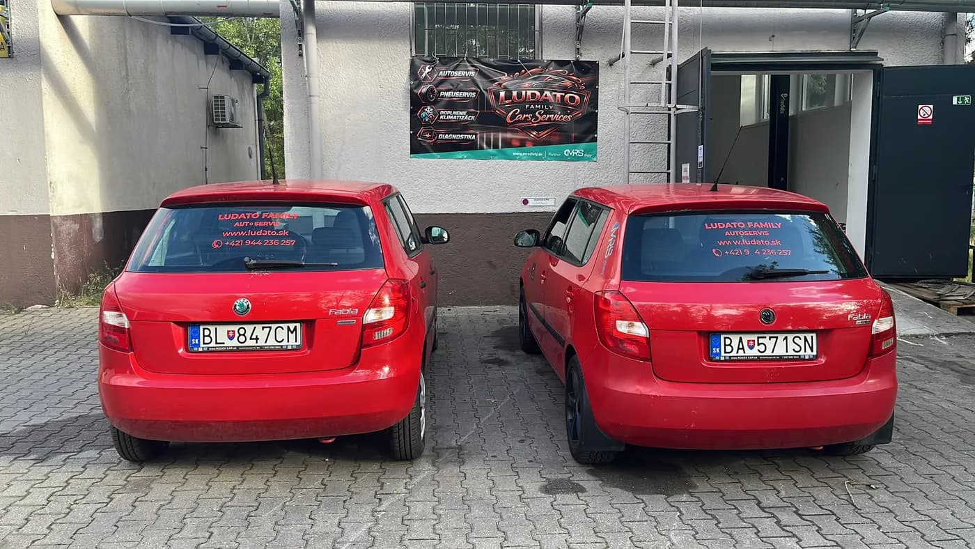 Dve červené náhradné vozidlá Škoda Fabia pred autoservisom Ludato Family na Odborárskej 52, Bratislava Nové Mesto