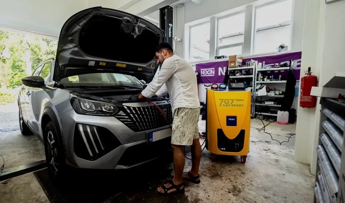 Mechanik pripája plničku klimatizácie k vozidlu v autoservise Ludato Family na Odborárskej v Bratislave, Novom Meste