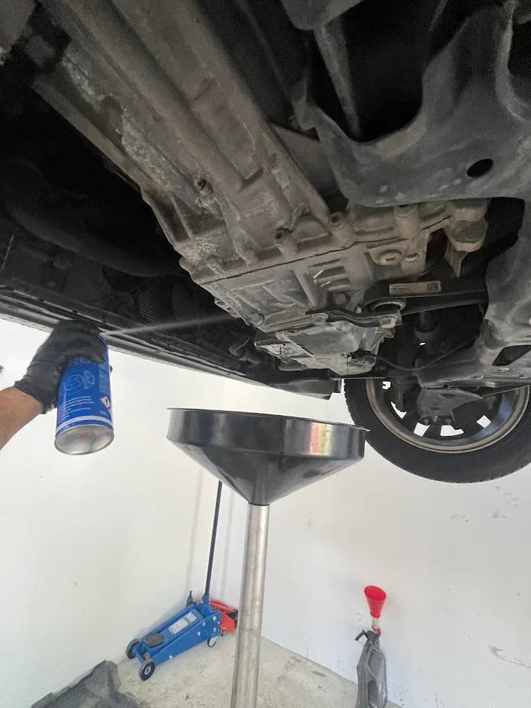 Výmena motorového oleja na zdvihnutom vozidle v autoservise Ludato Family na Odborárskej v Bratislave, Novom Meste